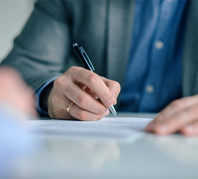 hombre firmando un documento